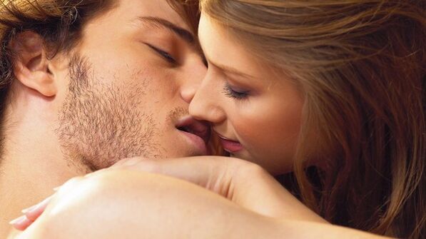 a woman kisses a man with potency products